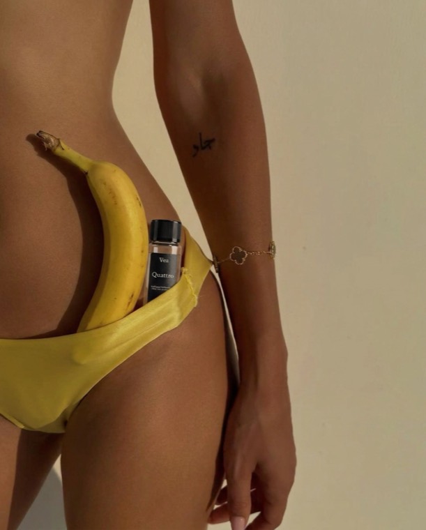 A bottle of Quattro by Vea Health and a banana tucked into a yellow swimsuit